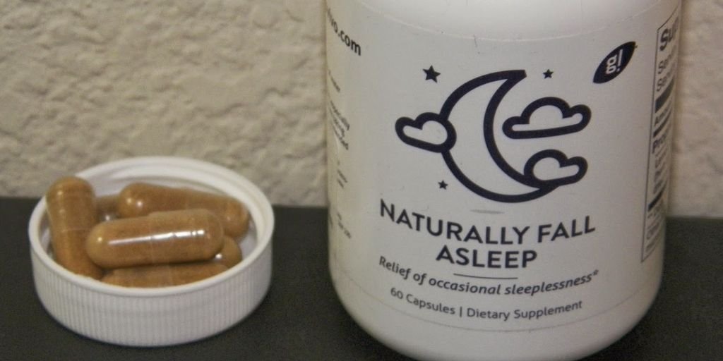 golden capsules with herbal ingredients on a wooden background