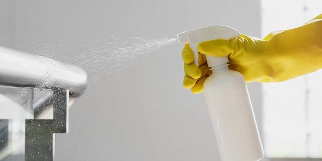 man using spray bottle in bedroom